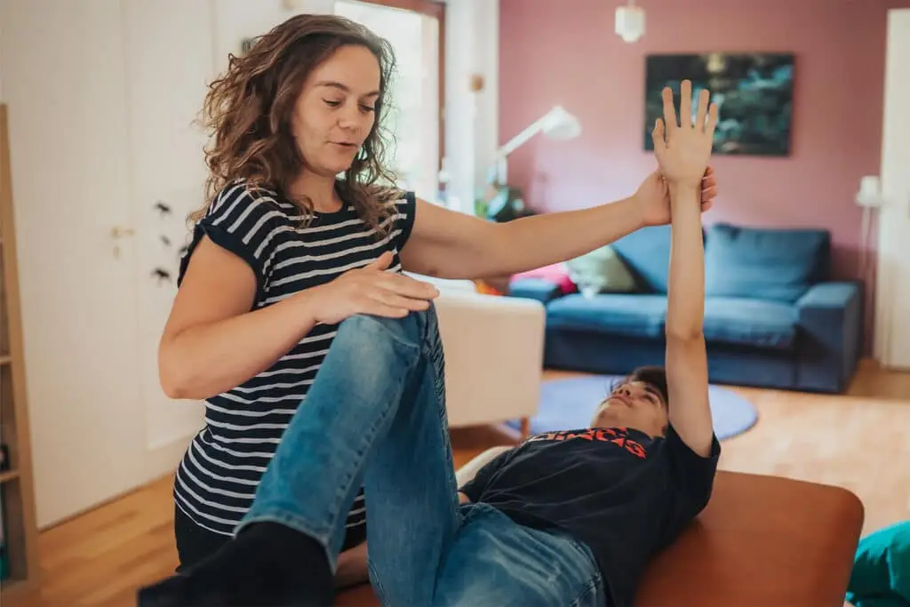 Claudia bei einer Übung für Reflexintegration mit einem jungen Menschen