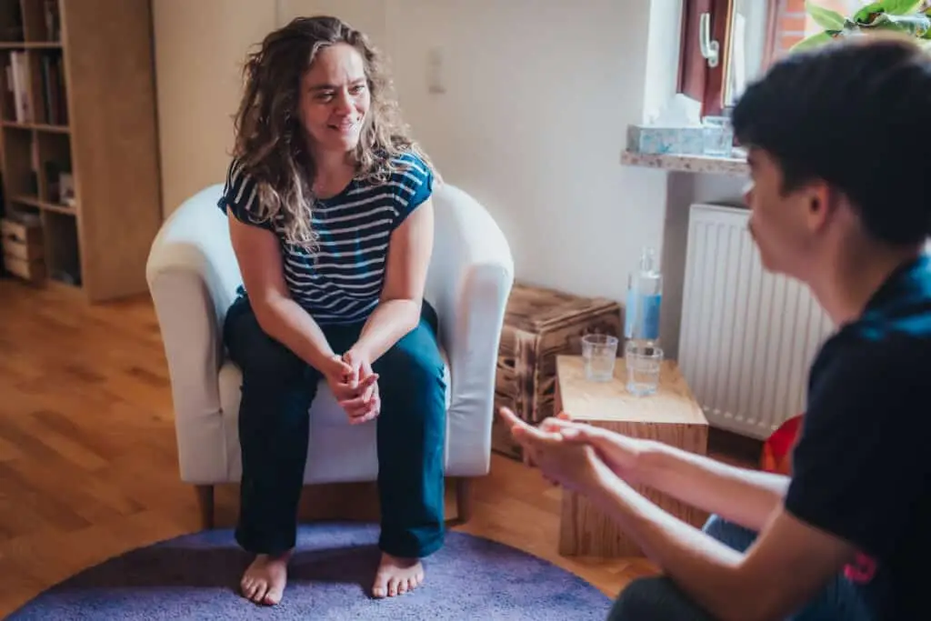 Reflexintegrationstrainerin Claudia Hannemann im Gespräch mit einem Jungen in ihrer Praxis – aufmerksam und zugewandt, ein Moment der Verbindung während der Reflexintegrationsarbeit bei ADHS-Symptomen
