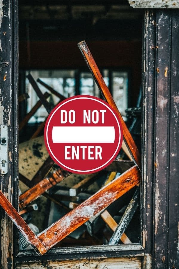 Zerstรถrte Tรผr mit Holztrรผmmern, durch die ein โDo Not Enterโ-Schild sichtbar ist โ Symbolbild fรผr innere Blockaden oder alte Schutzmechanismen.